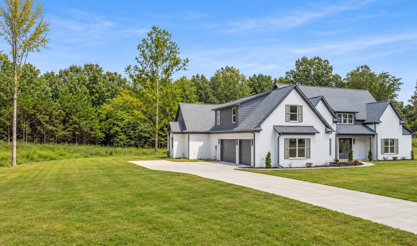 A finished home seen from the foot of its driveway